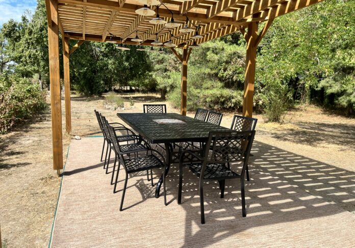 Ponnes pergola été de jour Espace extérieur du Logis des Ponnes, avec pergola, table, chaises et barbecue